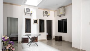 A spacious room with a glass table, air conditioning units, and a view of the outside. - RedDoorz Syariah near Stadion Teladan Medan (Medan)