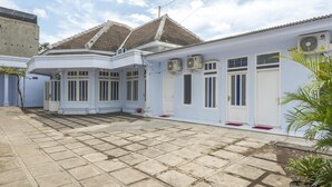 A traditional house with a tiled roof, white exterior walls, and multiple air conditioning units.