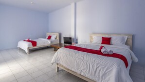 A hotel room with two single beds, a TV, and a wooden nightstand.