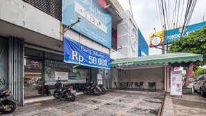 A storefront with a large sign advertising a price of Rp. 50,000.