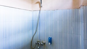 A tiled shower area with a handheld showerhead and a wall-mounted faucet. - RedDoorz @ Jalan Cendrawasih Timika (Timika)