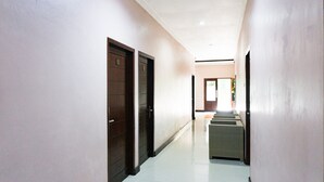 A hallway with two doors, a staircase, and a door leading to a room.