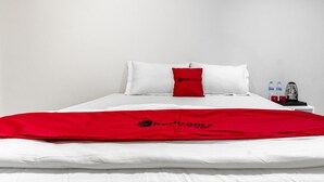 A bed with white bedding and a red blanket with RedDoorz logo. - RedDoorz Plus @ Gunungsari Surabaya (Surabaya)