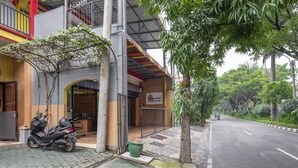 A building with a sign reading "millennial house" and a motorcycle parked outside. - RedDoorz Syariah @ Danau Kerinci Sawojajar (Malang)
