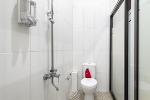 A small, modern bathroom with a toilet, shower, and glass door. - RedDoorz Syariah @ Danau Kerinci Sawojajar (Malang)