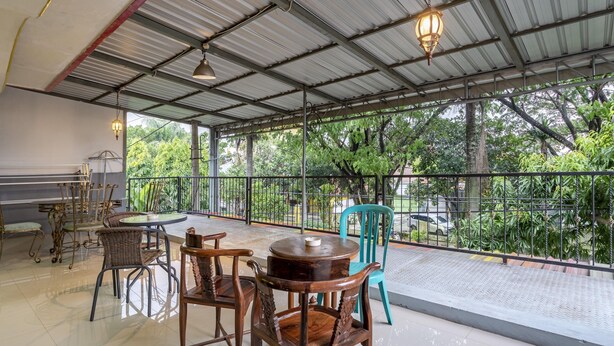 An indoor seating area with a view of greenery outside. - RedDoorz Syariah @ Danau Kerinci Sawojajar (Malang)