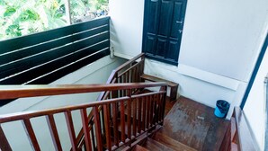 A wooden staircase with a handrail leading to a landing. - RedDoorz near Sentani Airport Jayapura (Sentani)