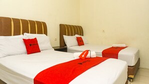Two single beds with white linens and red accents, including pillows and a blanket. Each bed has a wooden headboard and a nightstand. - RedDoorz near Sentani Airport Jayapura (Sentani)