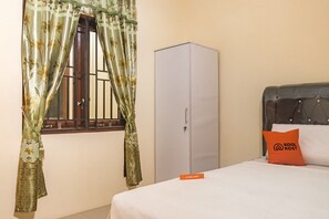 A bedroom with a bed, a wardrobe, and a window with curtains. - KoolKost Syariah @ Jamin Ginting Medan (Minimum Stay 3 Nights) (Medan)