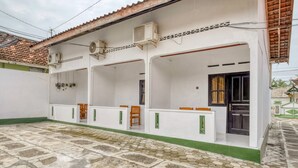 A white building with a tiled roof, air conditioning units, and a tiled ground floor. - RedDoorz near Wisata Pantai Parangtritis (Parangtritis)