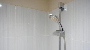 A shower with a handheld showerhead mounted on a wall. - RedDoorz near Lippo Plaza Buton (Bau-Bau)