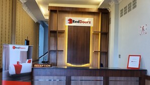 A reception desk with a RedDoorz sign, a reception area, and a sign advertising RedDoorz as the finest affordable accommodation. - RedDoorz near CitraLand Gama City Medan (Medan)