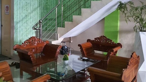 A modern interior with a staircase, green textured walls, and wooden furniture. - KoolKost Syariah @ Medan Johor (Medan)