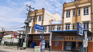 A building with multiple commercial establishments, including a visible sign for OPPLE LIGHTING and a bank. - KoolKost Syariah @ Medan Johor (Medan)