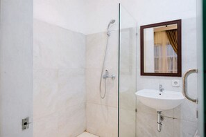 A modern bathroom with a glass shower enclosure, a white sink, and a mirror with a wooden frame.