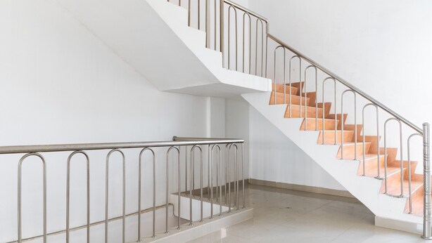 Una escalera moderna con barandillas de metal y escalones de madera.