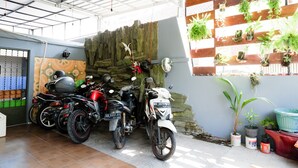 A covered parking area with motorcycles parked inside. - KoolKost Female Syariah near UII Taman Siswa (Yogyakarta)