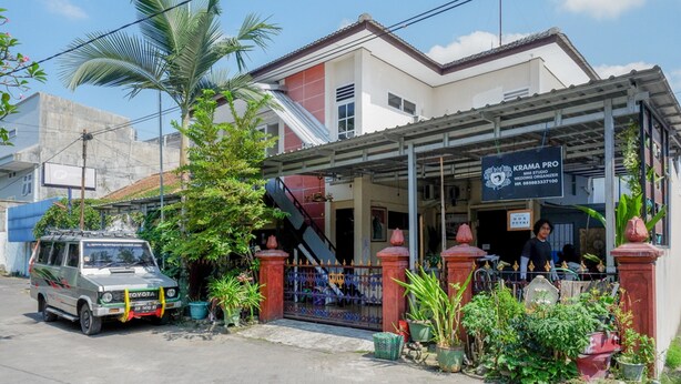 A building with a covered entrance, a sign for a wedding organizer, and a parked vehicle. - KoolKost Female Syariah near UII Taman Siswa (Yogyakarta)