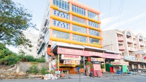 A multi-story hotel with signage for 'ERGO HOTEL' and 'Chicken Deli' on the ground floor. - RedDoorz Plus near Vigan City Commercial Center (Vigan)