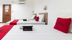 A hotel room with two beds, a wooden door, an air conditioning unit, and a wall-mounted light fixture. - RedDoorz Plus near Vigan City Commercial Center (Vigan)