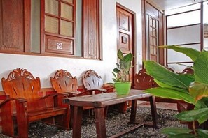 Een kamer met houten meubels, een tafel en potplanten.
