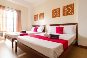 A hotel room with two beds, a large window with curtains, and decorative wall panels. - RedDoorz Plus near Johnson and Johnson Paranaque (Parañaque)