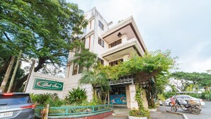 A Shell Inn building with a sign, surrounded by greenery and parked vehicles. - RedDoorz @ Arimbay Legazpi City - Hostel (Legazpi)