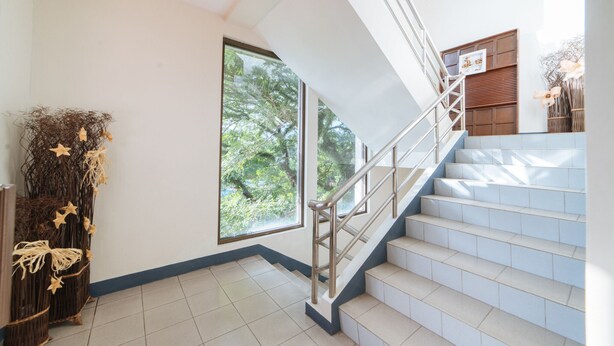 A staircase with a metal handrail leading to a landing. - RedDoorz @ Arimbay Legazpi City - Hostel (Legazpi)