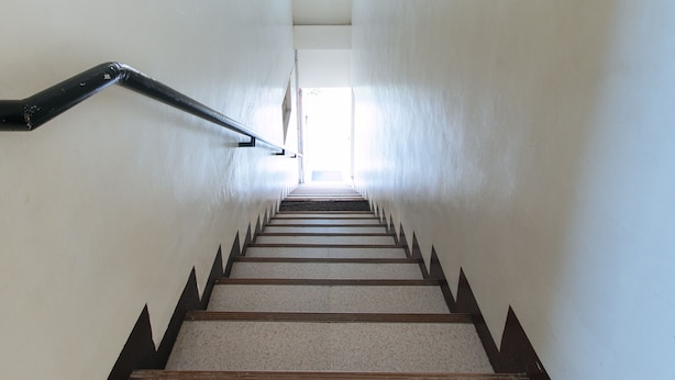 A staircase with a handrail and a view of the outdoors. - RedDoorz @ Golite Washington - Hostel (Legazpi)