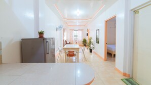 Habitació d'hotel moderna amb zona de menjador, petita cuina i llit.