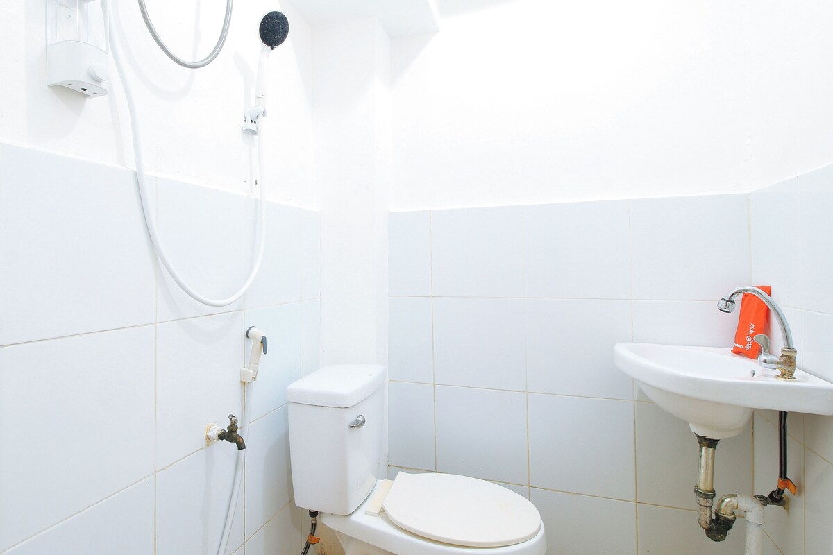 Un baño con azulejos blancos, inodoro, lavabo y ducha.