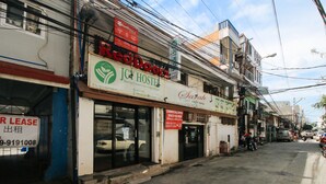 A commercial building with multiple storefronts, including a hostel and a cafe. - RedDoorz near OWWA Pasay (Pasay)