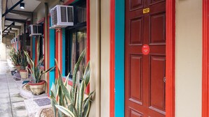 A row of red doors with a sign indicating room number 107. - RedDoorz @ Bankal Lapulapu (Lapu-Lapu)
