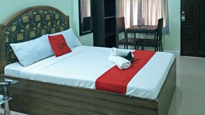 A neatly made bed with white and red bedding, a wooden headboard, and a red throw pillow. - RedDoorz @ Bankal Lapulapu (Lapu-Lapu)