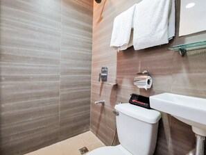 Een moderne badkamer met een douche, toilet en wastafel.