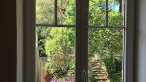 Blick durch ein Fenster mit weißem Rahmen und weißem Zaun.