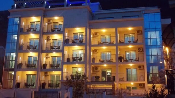 Un hôtel à plusieurs étages doté de balcons, de grandes fenêtres et de systèmes de climatisation.