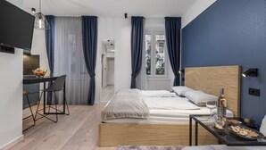 A modern bedroom with a bed, bedside table, and a desk with a chair. - Deluxe Apartments & Rooms In the Center (Rijeka)