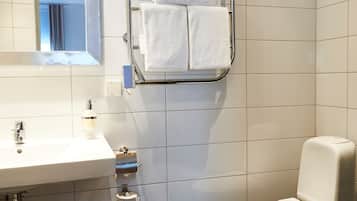 Une salle de bain moderne avec un lavabo blanc, un miroir et des toilettes.