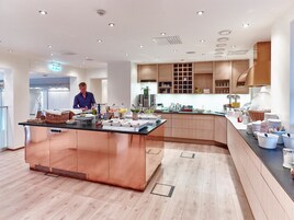 Una cocina moderna con una isla central, armarios de madera y una campana extractora de acero inoxidable.