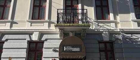 Un edificio de varios pisos con un estilo arquitectónico clásico, que presenta una entrada central con un letrero que dice "HOTEL STADSPARKEN".