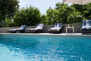 A swimming pool with lounge chairs and a stone wall. - Villa Lorenzo (Lovran)