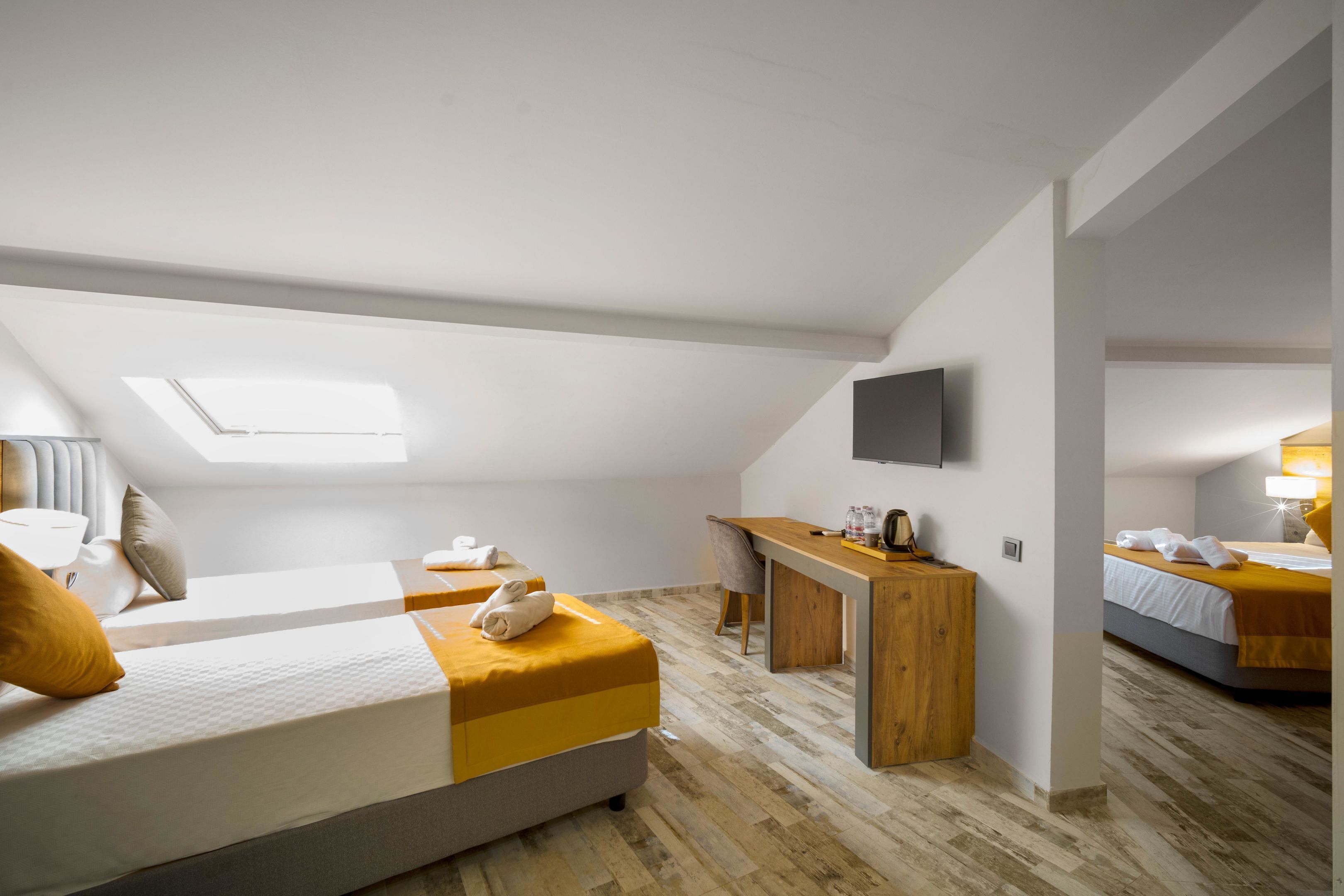 Una habitación de hotel moderna con cama de altillo, escritorio y televisor de pantalla plana.