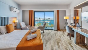 A hotel room with a bed, desk, chairs, and a balcony with a view. - Dalya Resort Aqua & Spa Hotel (Datça)