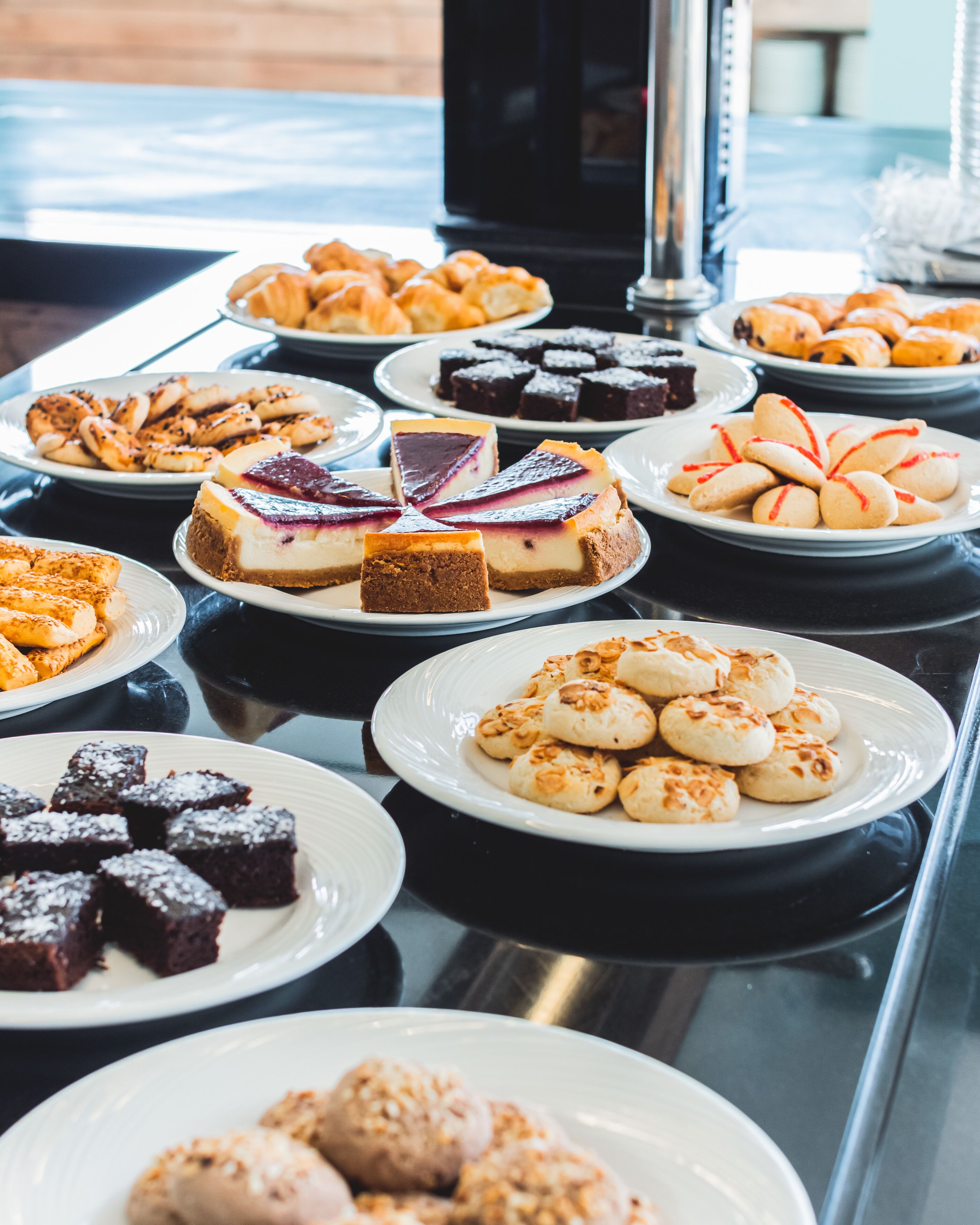 Ein Buffet mit verschiedenen Desserts, darunter Kuchen, Torten und Gebäck.