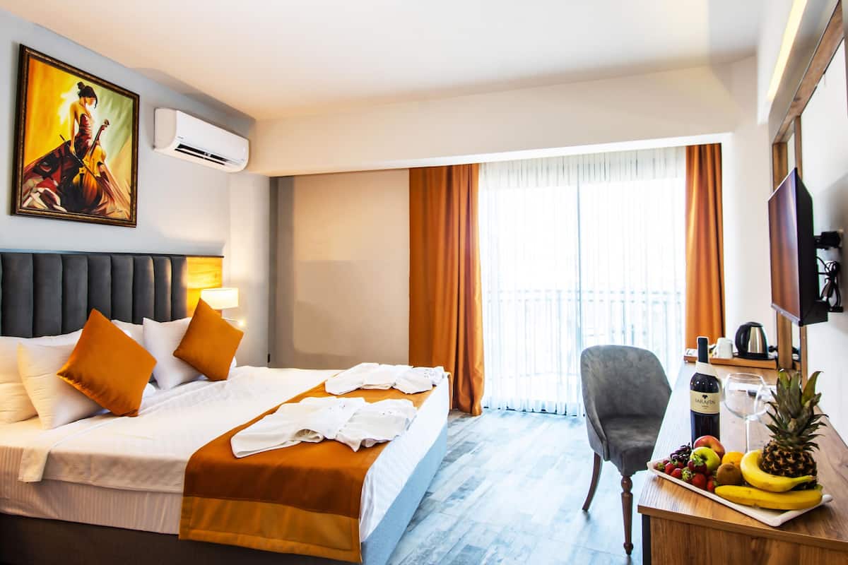 Deluxe kamer, uitzicht op zee | 1 slaapkamer, een minibar met enkele gratis items, een kluis op de kamer