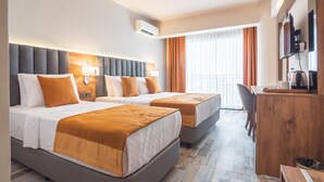 A hotel room with two beds, a desk, a chair, an air conditioning unit, and a television. - Dalya Resort Aqua & Spa Hotel (Datça)