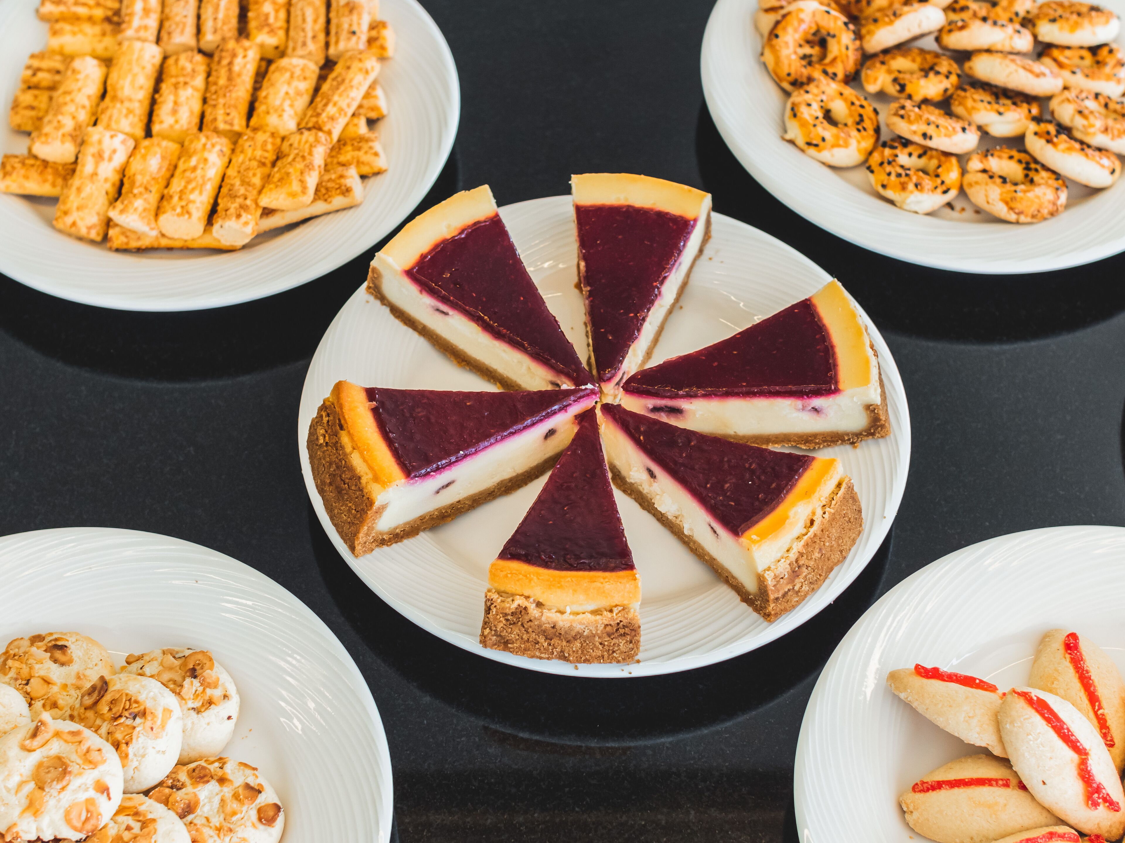 A dessert table with various types of cakes and pastries.