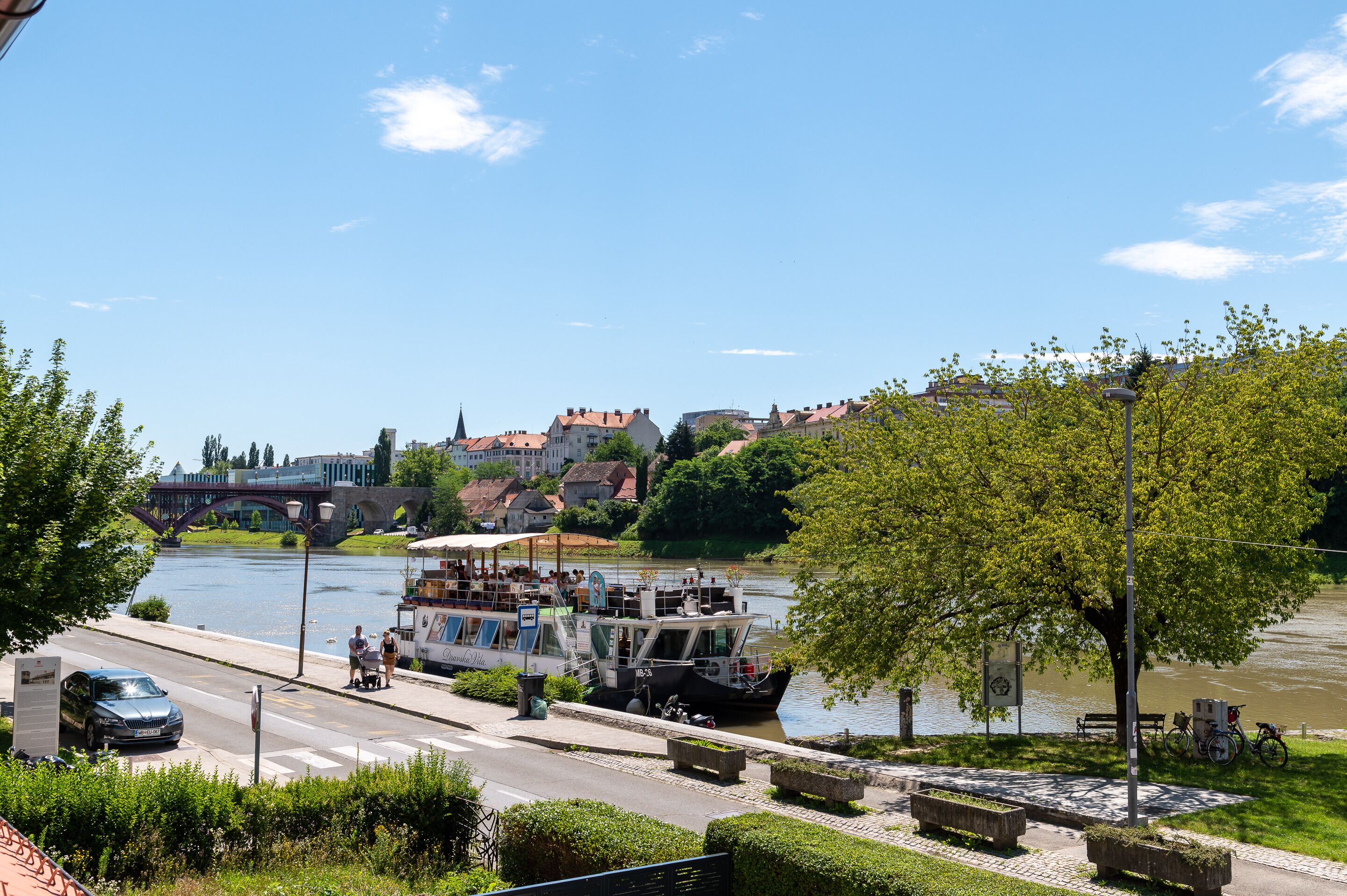 A river with a boat, a bridge, and buildings in the background.