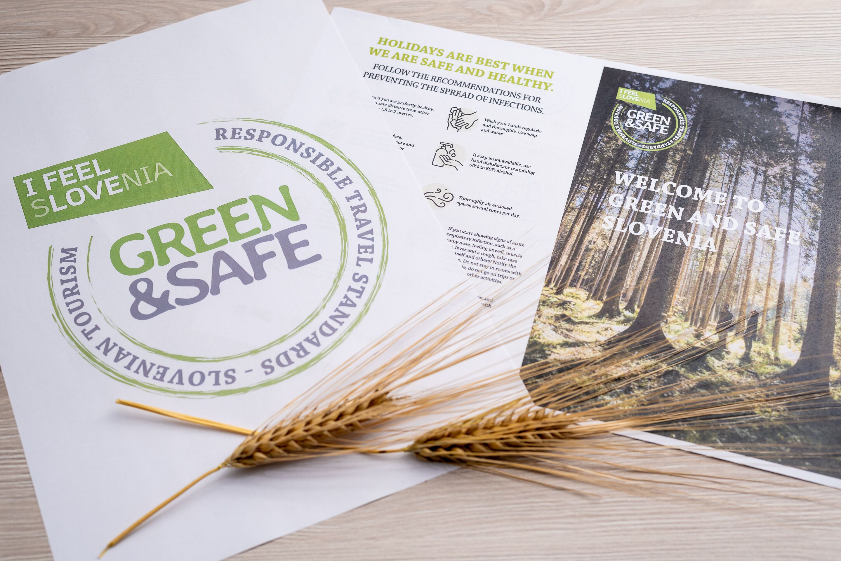 Eine Broschüre mit dem Titel "Green & Safe Slovenia", die ein Waldbild zeigt und Informationen über verantwortungsvolles Reisen sowie Gesundheitsempfehlungen enthält.